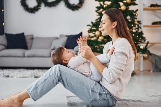 Holiday mood. Mother with her little daughter is indoors at home together.