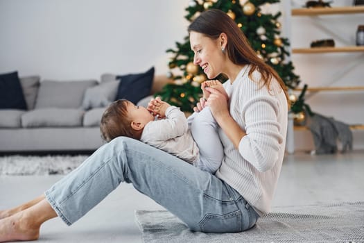 Holiday mood. Mother with her little daughter is indoors at home together.