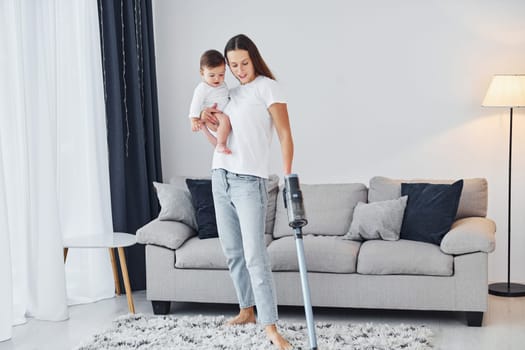 Domestic life. Mother with her little daughter is indoors at home together.