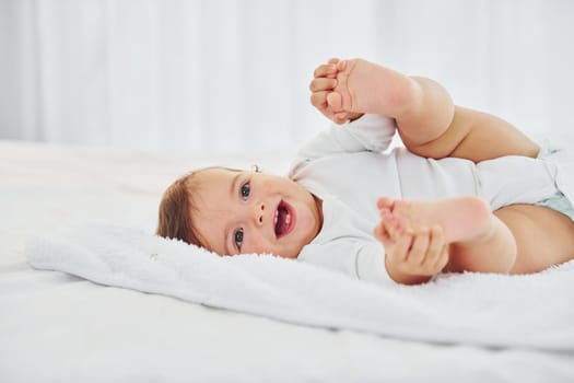 Having fun. Cute little baby is indoors in the domestic room.