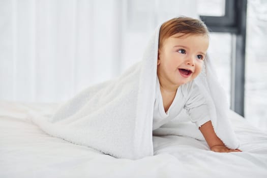 Having fun. Cute little baby is indoors in the domestic room.