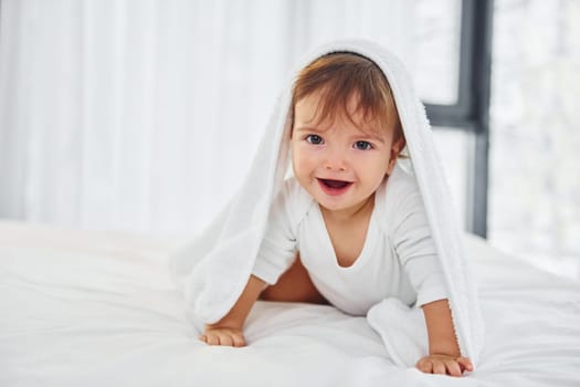 Having fun. Cute little baby is indoors in the domestic room.