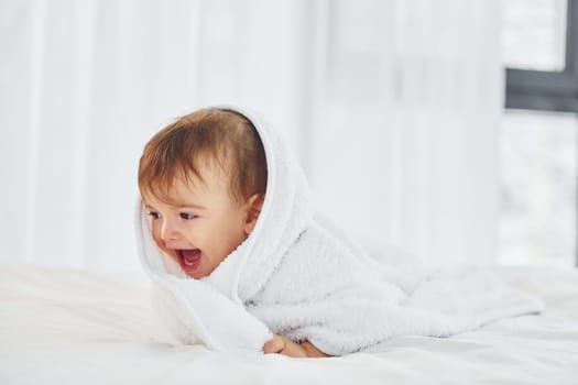 Positive emotions. Cute little baby is indoors in the domestic room.