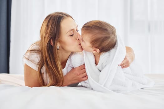 Conception of parenting. Mother with her little daughter is indoors at home together.