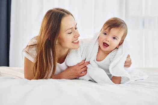 Conception of parenting. Mother with her little daughter is indoors at home together.