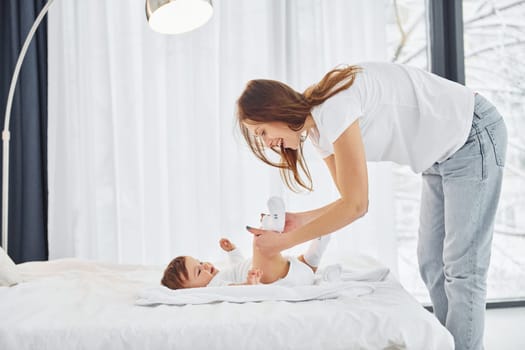 Conception of parenting. Mother with her little daughter is indoors at home together.
