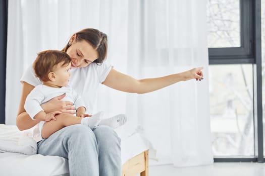 Conception of parenting. Mother with her little daughter is indoors at home together.