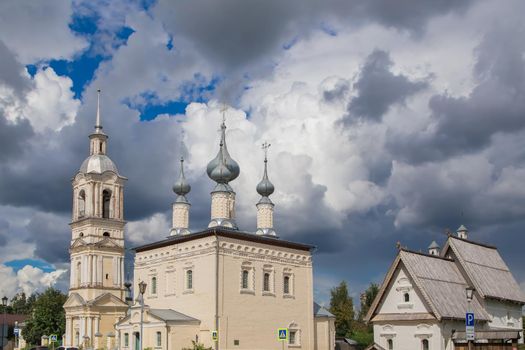 Gloomy clouds hang over the Christian temple. An old white stone church on a city street before the rain. Warm summer day, soft light.