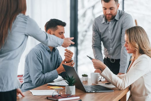 Using brainstorming technique. Group of business people that working on the project in the office.