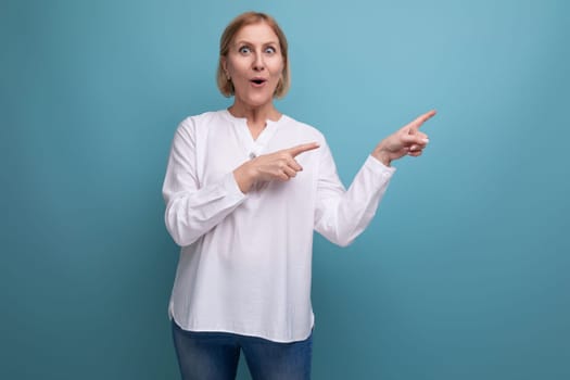 surprised shocked middle aged blonde bob woman in white blouse on studio background.