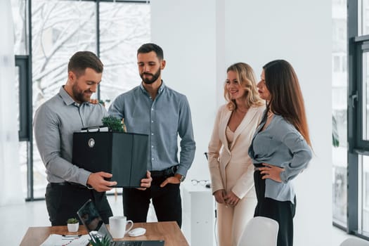 Holding package in hands. Group of business people that working on the project in the office.