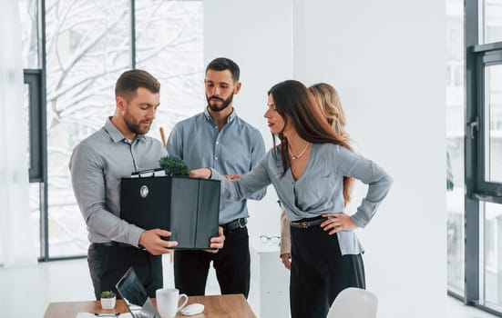 Holding package in hands. Group of business people that working on the project in the office.