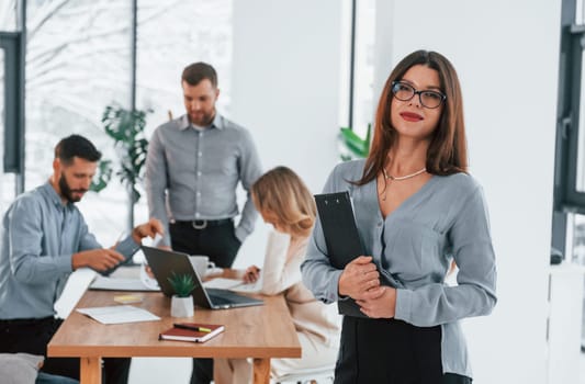 Woman standing in front of her employees. Group of business people that working on the project in the office.