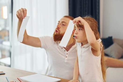 Having fun. Father with his little daughter is at home together.