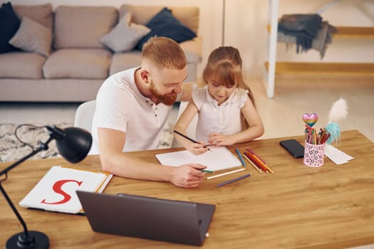 Online learning. Father with his little daughter is at home together.