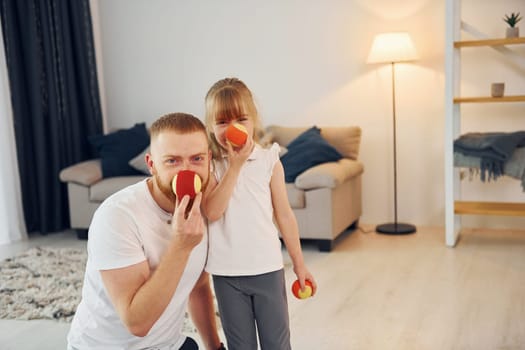 Holding balls. Father with his little daughter is at home together.