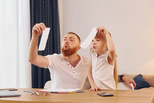 Father with his little daughter is at home together.