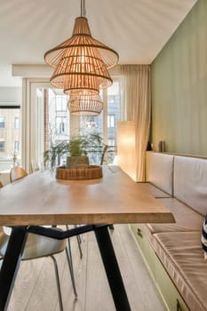 a dining room with a wooden table and two chairs in front of a large window that looks out onto the street