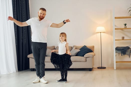 Yoga poses. Father with his little daughter is at home together.