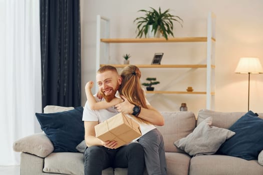 With gift box. Father with his little daughter is at home together.