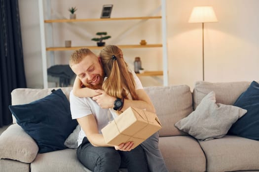 With gift box. Father with his little daughter is at home together.