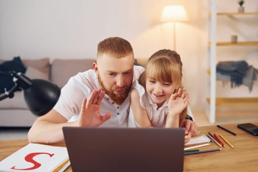 Online learning. Father with his little daughter is at home together.