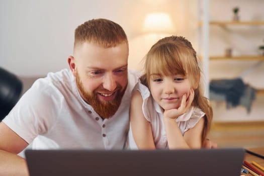 Online learning. Father with his little daughter is at home together.