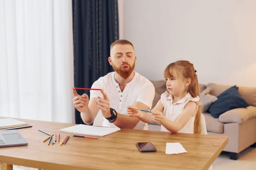 Cozy atmosphere. Father with his little daughter is at home together.