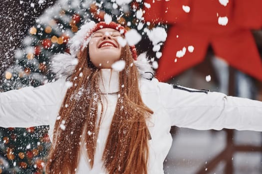 Happy young woman standing outdoors and celebrating christmas holidays.
