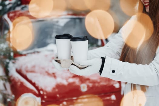 Close up view of woman's hands that holding two cups of drink.