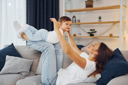 Woman holding little girl in hands. Mother with her little daughter is at home together.