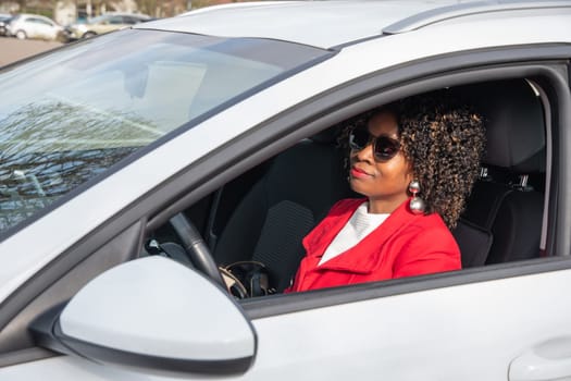 Pretty african american woman in a car doing makeup while standing in a traffic jam, concept a modern married business woman with children saves time, High quality photo