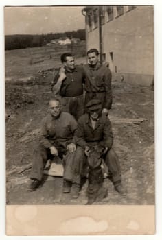 THE CZECHOSLOVAK REPUBLIC - CIRCA 1940s: Vintage photo shows a group of workers - labours poses outdoor. Retro black and white photography. Circa 1940s.