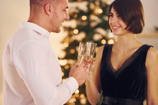 Happy couple have a new year party indoors together.