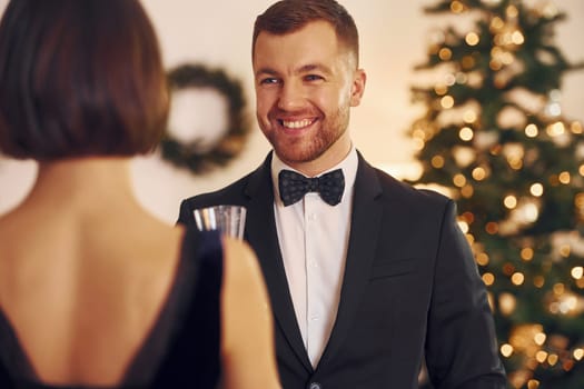 Happy couple have a new year party indoors together.