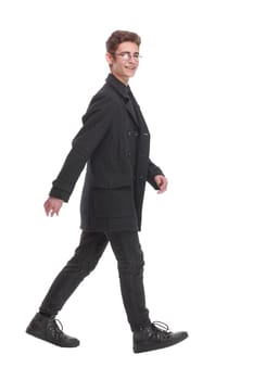 Side view of a fashion young man walking forward over white. Isolated over white background