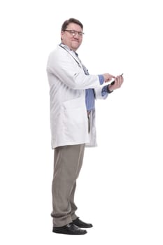 in full growth. qualified doctor with a smartphone.isolated on a white background.
