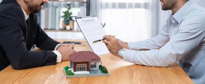 Client review loan contract with real estate agent, discussing term, interest and property ownership. Analyzing legal document, reading agreement before deciding. Real estate transaction. Fervent