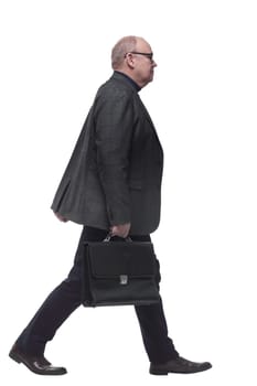 side view. a business man with a leather briefcase striding forward. isolated on a white background