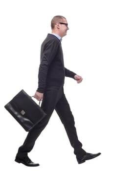 Full length side view picture of a young business man walking with a suitcase in his hand and a smile on his face. on white background