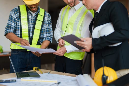 multi ethnic engineer brainstorming and measuring for cost estimating on paperworks and floor plan drawings about design architectural and engineering for houses and buildings.