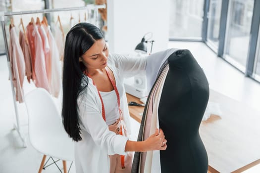 Busy at work. Seamstress is in her office that is with different clothes.