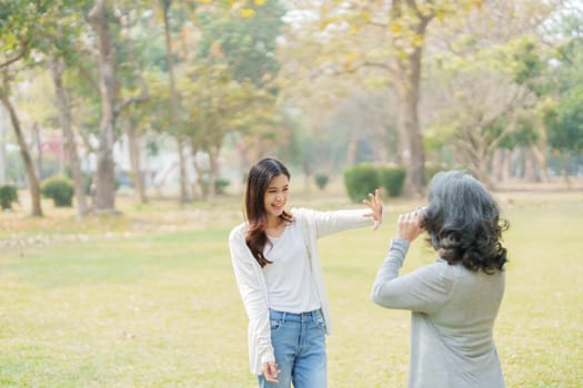Asian teenage mother and daughter walking in park with camera to capture memories.