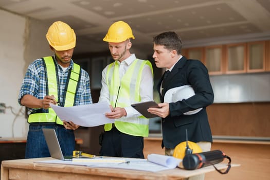 multi ethnic engineer brainstorming and measuring for cost estimating on paperworks and floor plan drawings about design architectural and engineering for houses and buildings.