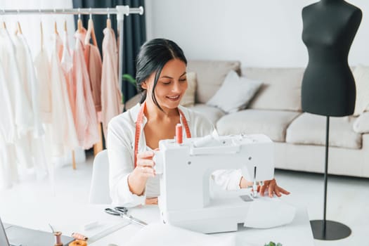 Professional equipment. Seamstress is in her office that is with different clothes.