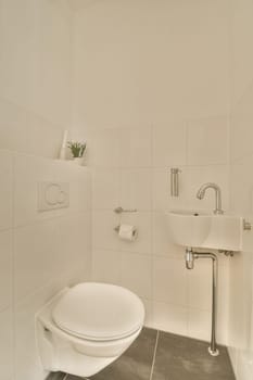 a bathroom with a toilet and sink in the corner, taken from above it is a plant on the wall