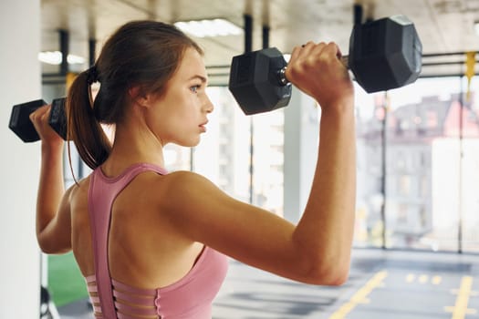 Young woman with slim body type is in the gym.