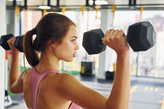 Young woman with slim body type is in the gym.