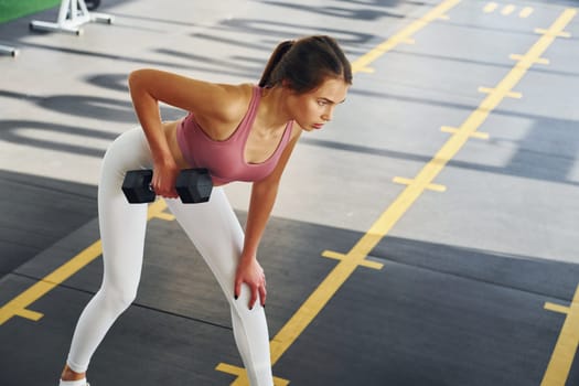 Young woman with slim body type is in the gym.