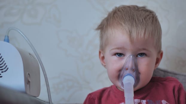 Funny boy breathing through an inhaler mask